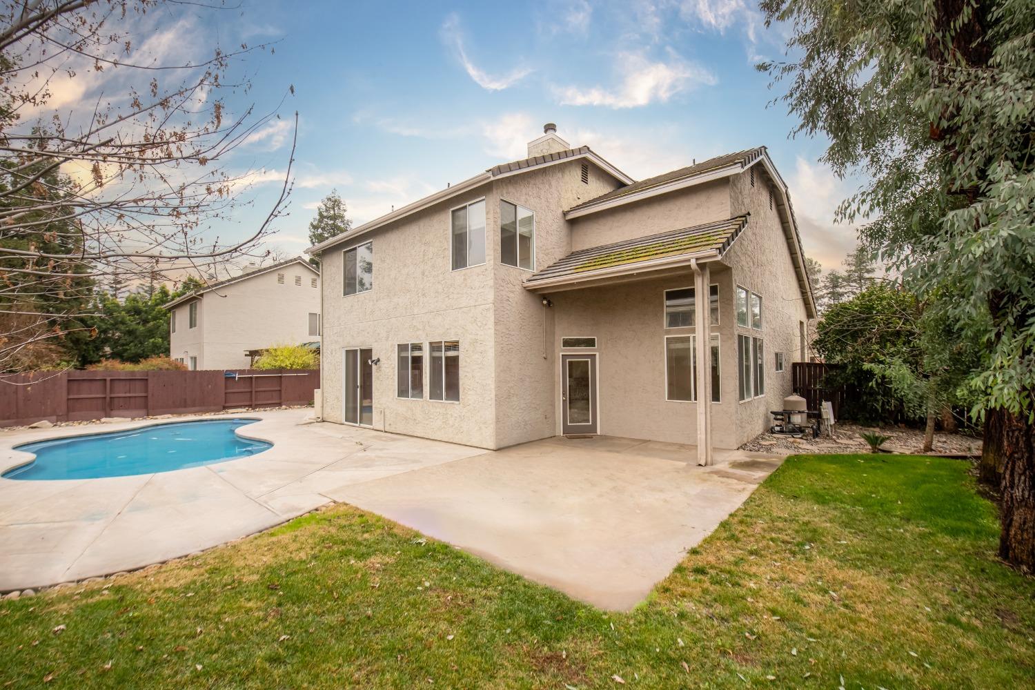 1361 Birch Avenue Clovis, CA 93611 - Photo 6 of 43 a view of a white house with a big yard and large trees