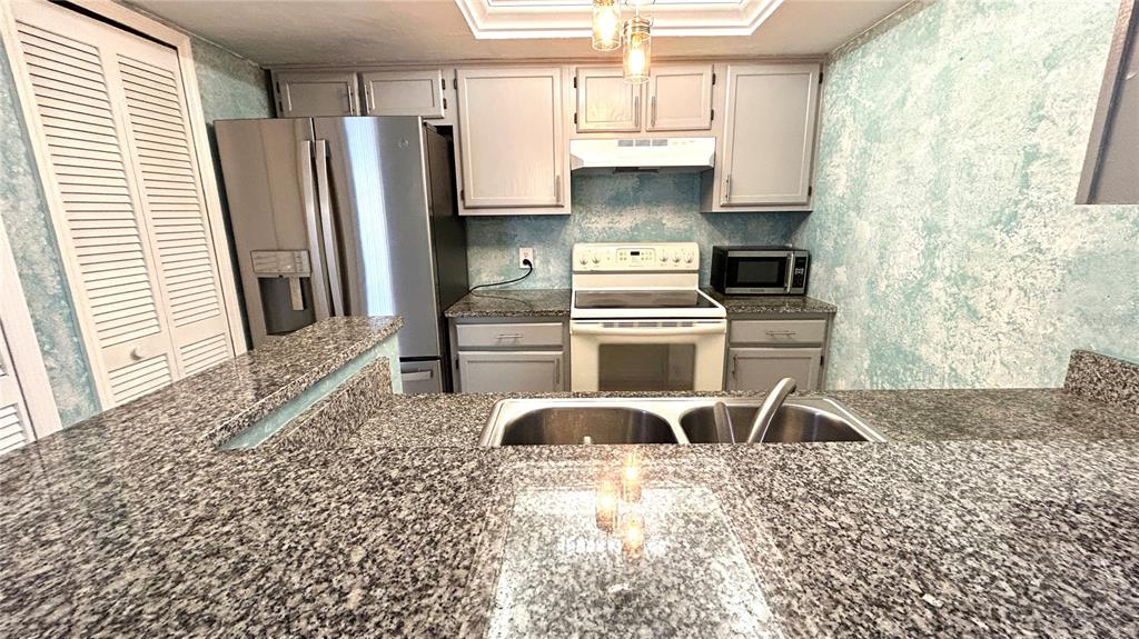 5855 Southwest 8th Place Gainesville, FL 32607 - Photo 11 of 19 a kitchen with stainless steel appliances granite countertop a stove a refrigerator and a sink