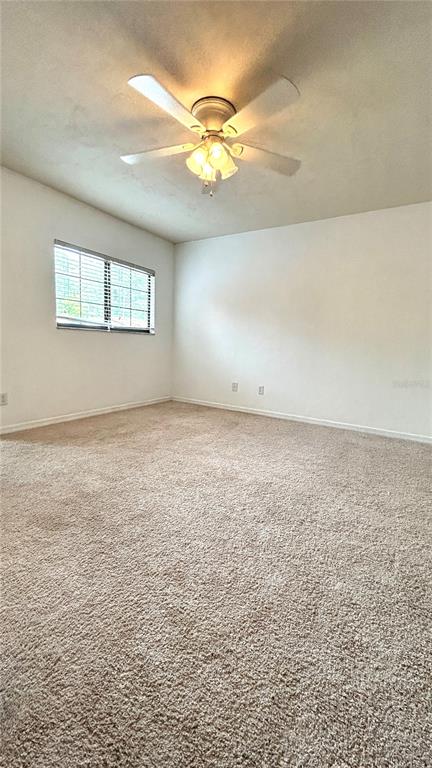 5855 Southwest 8th Place Gainesville, FL 32607 - Photo 13 of 19 an empty room with a chandelier fan and windows