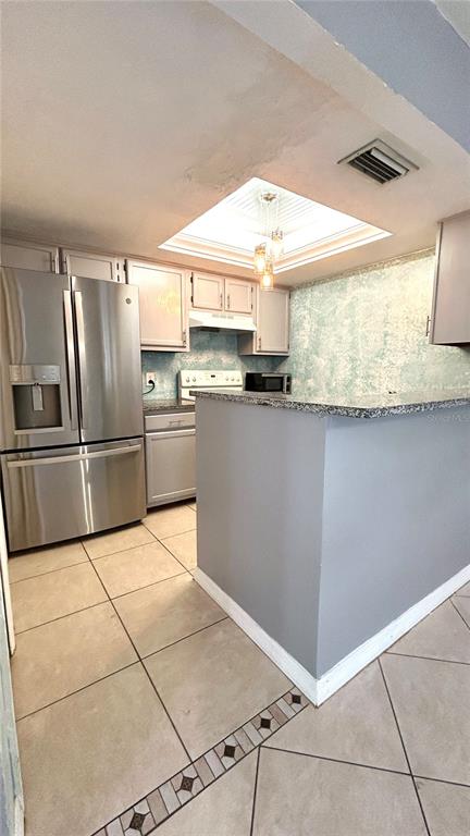 5855 Southwest 8th Place Gainesville, FL 32607 - Photo 10 of 19 a kitchen with granite countertop a refrigerator and stove