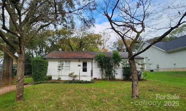 a front view of a house with a yard and trees