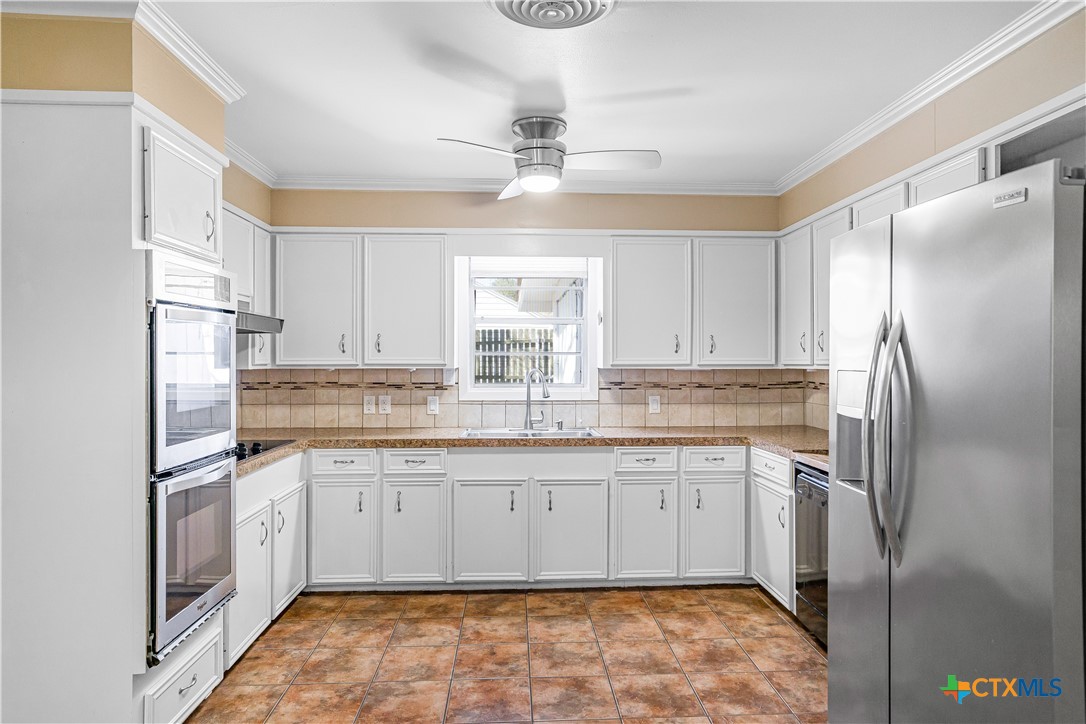 121 Bonham Street Port Lavaca, TX 77979 - Photo 5 of 26 a kitchen with granite countertop a sink stainless steel appliances and cabinets
