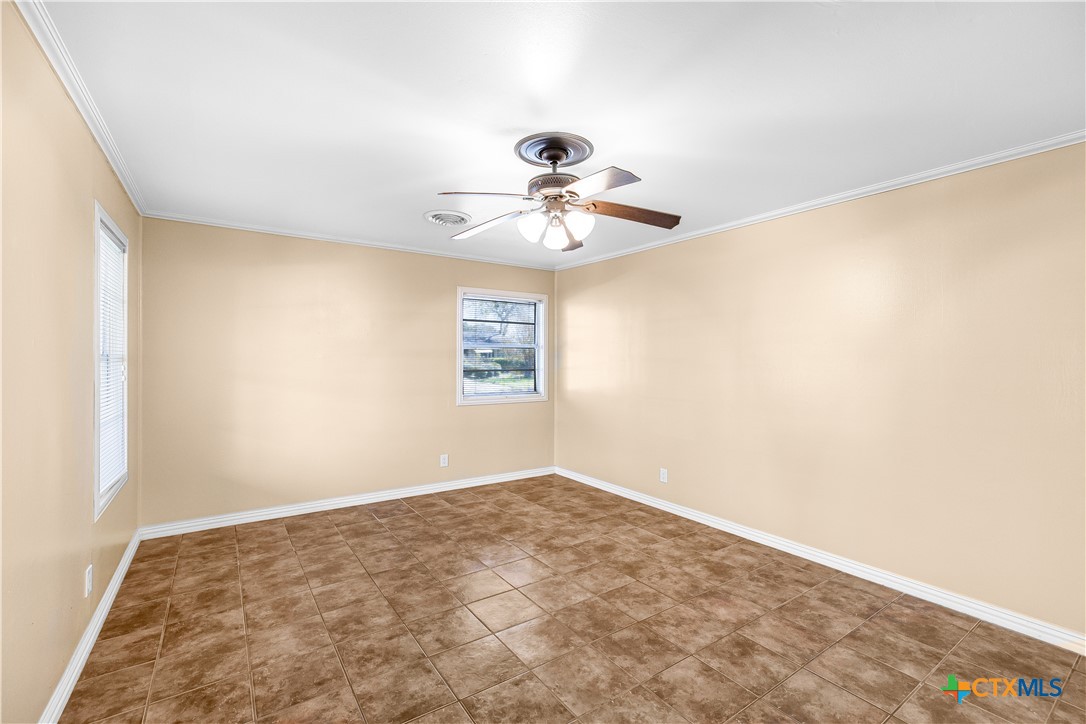 121 Bonham Street Port Lavaca, TX 77979 - Photo 9 of 26 an empty room with a chandelier fan and windows