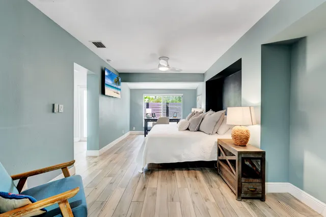 a bedroom with a bed and wooden floor
