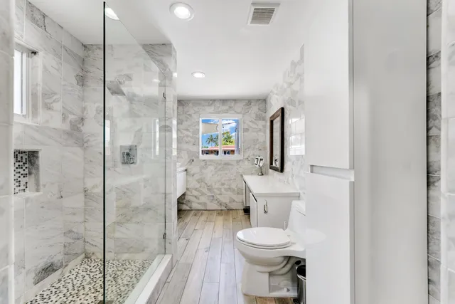 a bathroom with a toilet a sink and shower