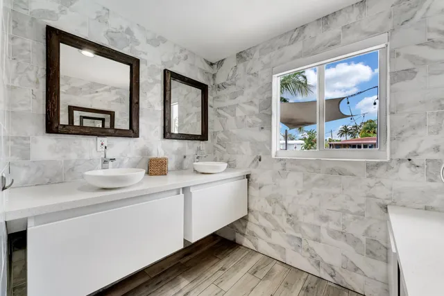 a bathroom with a double vanity sink mirror and a window