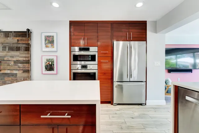 a kitchen with stainless steel appliances a refrigerator and a stove top oven