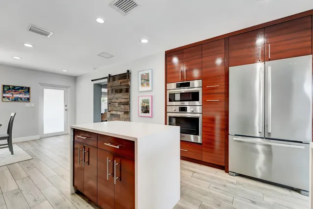 a kitchen with stainless steel appliances granite countertop a refrigerator and a stove