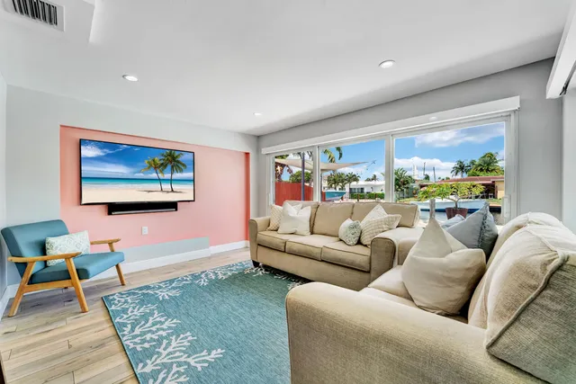a living room with furniture a rug and a large window
