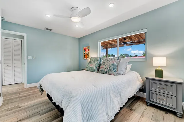 a bedroom with bed and wooden floor