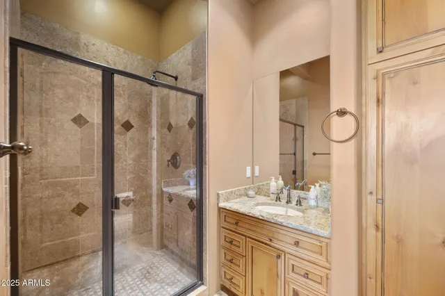a bathroom with a granite countertop sink a mirror and shower