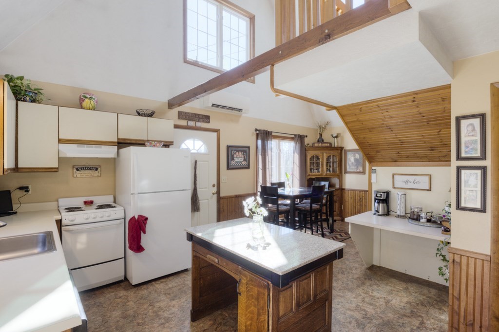 51 Webber Road Brookfield, MA 01506 - Photo 8 of 42 a kitchen that has a kitchen island a stove a microwave a dining table and chairs