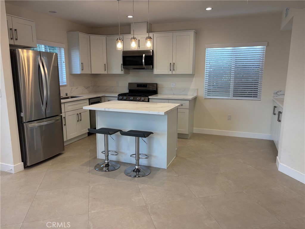 9353 Crystal View Drive Tujunga, CA 91042 - Photo 3 of 8 a kitchen with a refrigerator a stove a microwave and cabinets