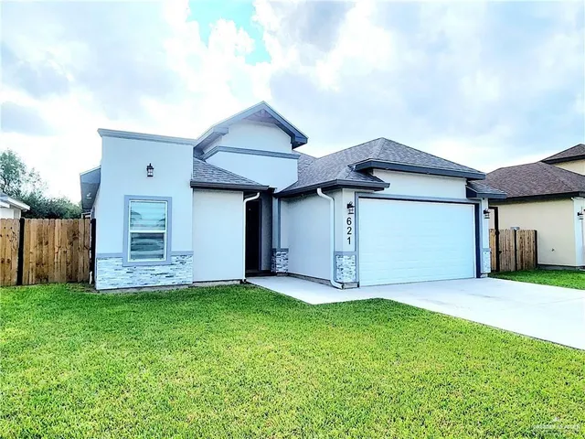 a front view of a house with a yard and garage