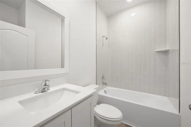 a bathroom with a bathtub shower sink vanity mirror and toilet