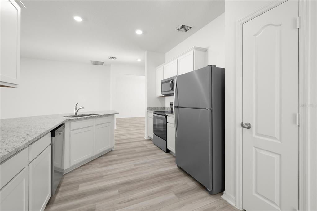 13284 Tula Loop Astatula, FL 34705 - Photo 4 of 24 a kitchen with stainless steel appliances a refrigerator and a sink