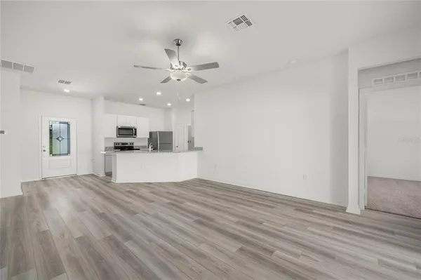 a view of kitchen with granite countertop cabinets and refrigerator