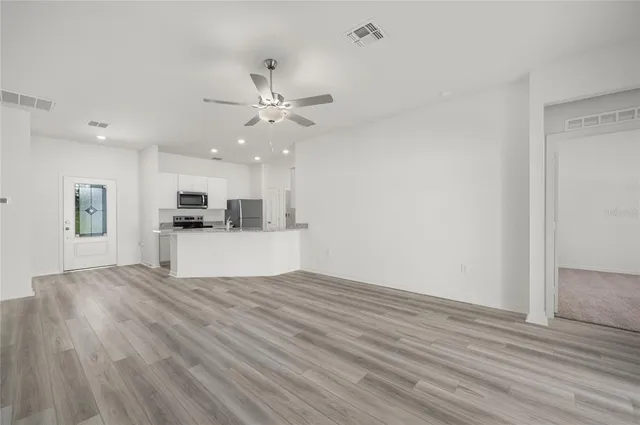 a view of kitchen with granite countertop cabinets and refrigerator