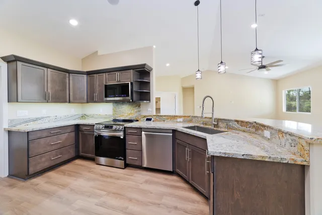 a kitchen with stainless steel appliances granite countertop a sink and stove top oven