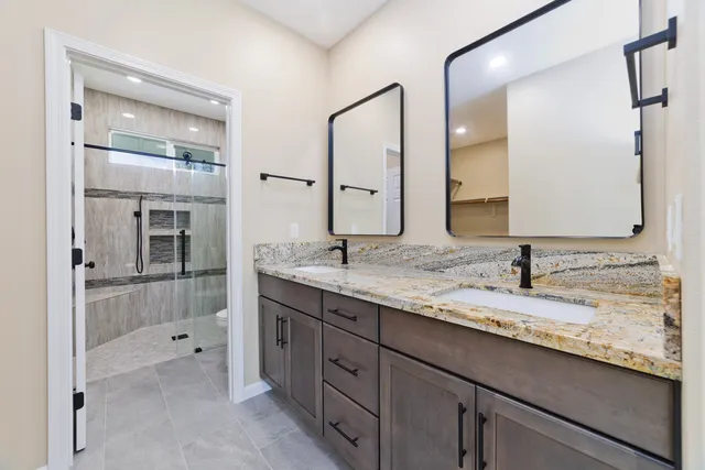a bathroom with a granite countertop sink and a mirror
