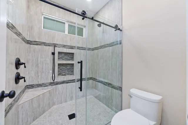 a bathroom with a toilet and a shower