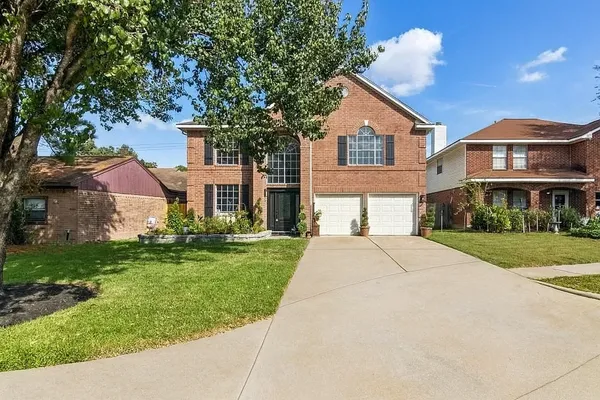 a front view of a house with a yard and trees
