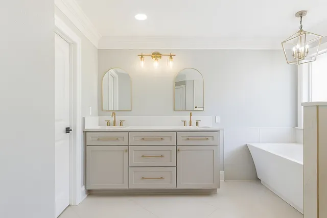 a spacious bathroom with a double vanity sink mirror and bathtub