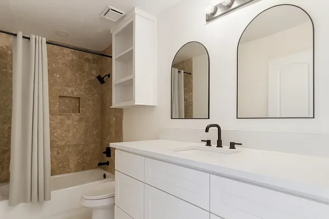 a bathroom with a sink a toilet and a mirror