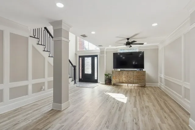 a view of a livingroom with wooden floor and stairs