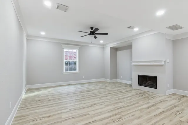 a view of an empty room with a fireplace and a window