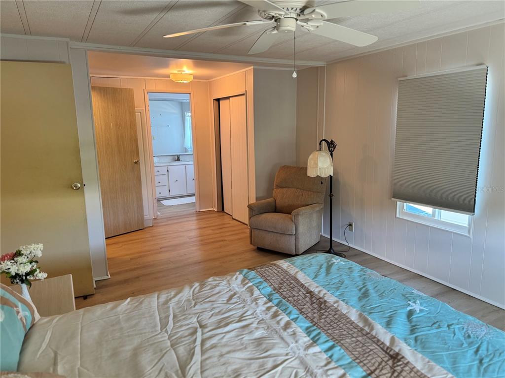 1891 Englewood Road, Unit 45 Englewood, FL 34223 - Photo 20 of 55 a bedroom with a bed and a chandelier