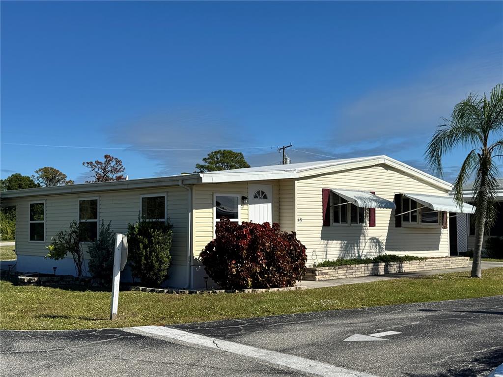 1891 Englewood Road, Unit 45 Englewood, FL 34223 - Photo 2 of 55 a front view of house with yard and green space
