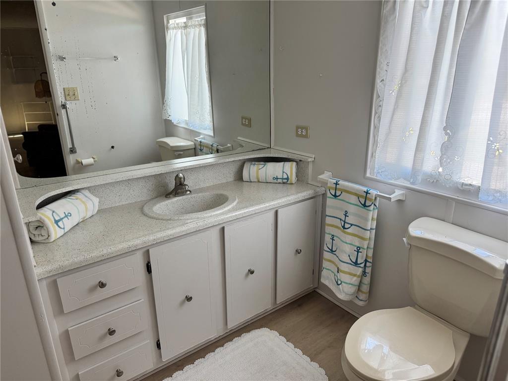 1891 Englewood Road, Unit 45 Englewood, FL 34223 - Photo 21 of 55 a bathroom with a toilet sink and mirror