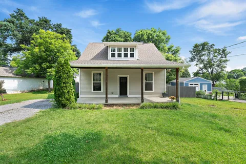 a front view of a house with a yard and trees