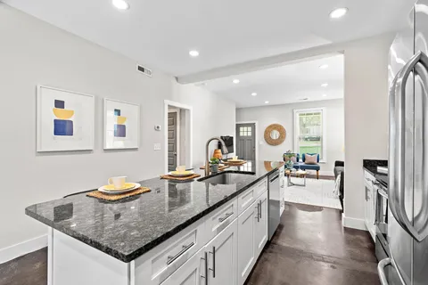 a kitchen with stainless steel appliances granite countertop a sink stove and refrigerator