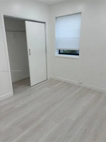 an empty room with wooden floor and mirror