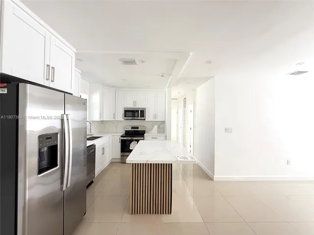 a kitchen with stainless steel appliances a refrigerator sink and stove