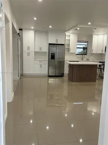 a kitchen with stainless steel appliances granite countertop a refrigerator and a sink