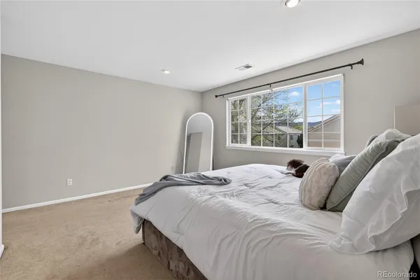 a bedroom with a bed and a large window
