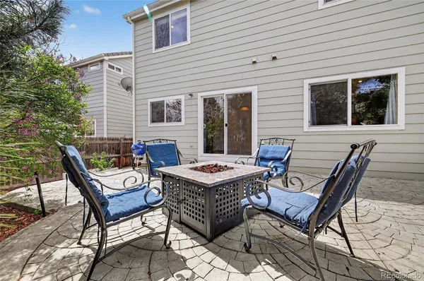 a backyard of a house with barbeque oven table and chairs