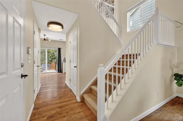 a view of staircase with lots of frames on wall and wooden floor