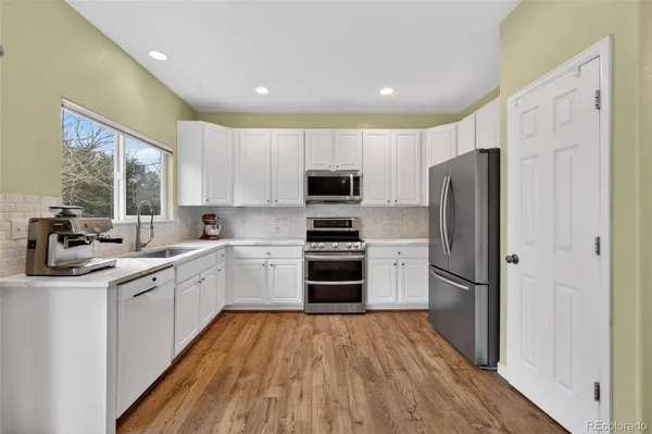 a kitchen with a refrigerator stove and sink