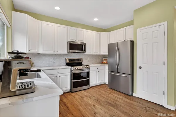 a kitchen with kitchen island a refrigerator stove and microwave