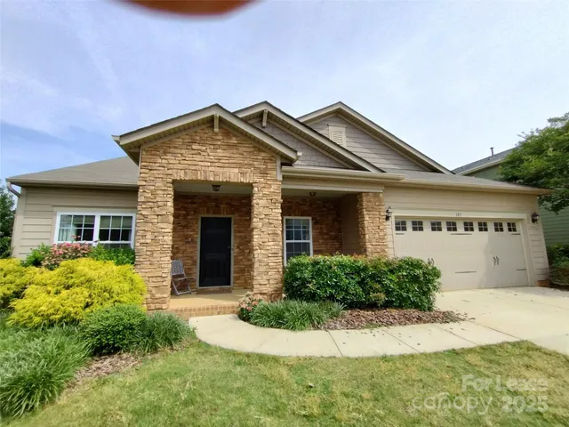 a front view of a house with a garden and plants