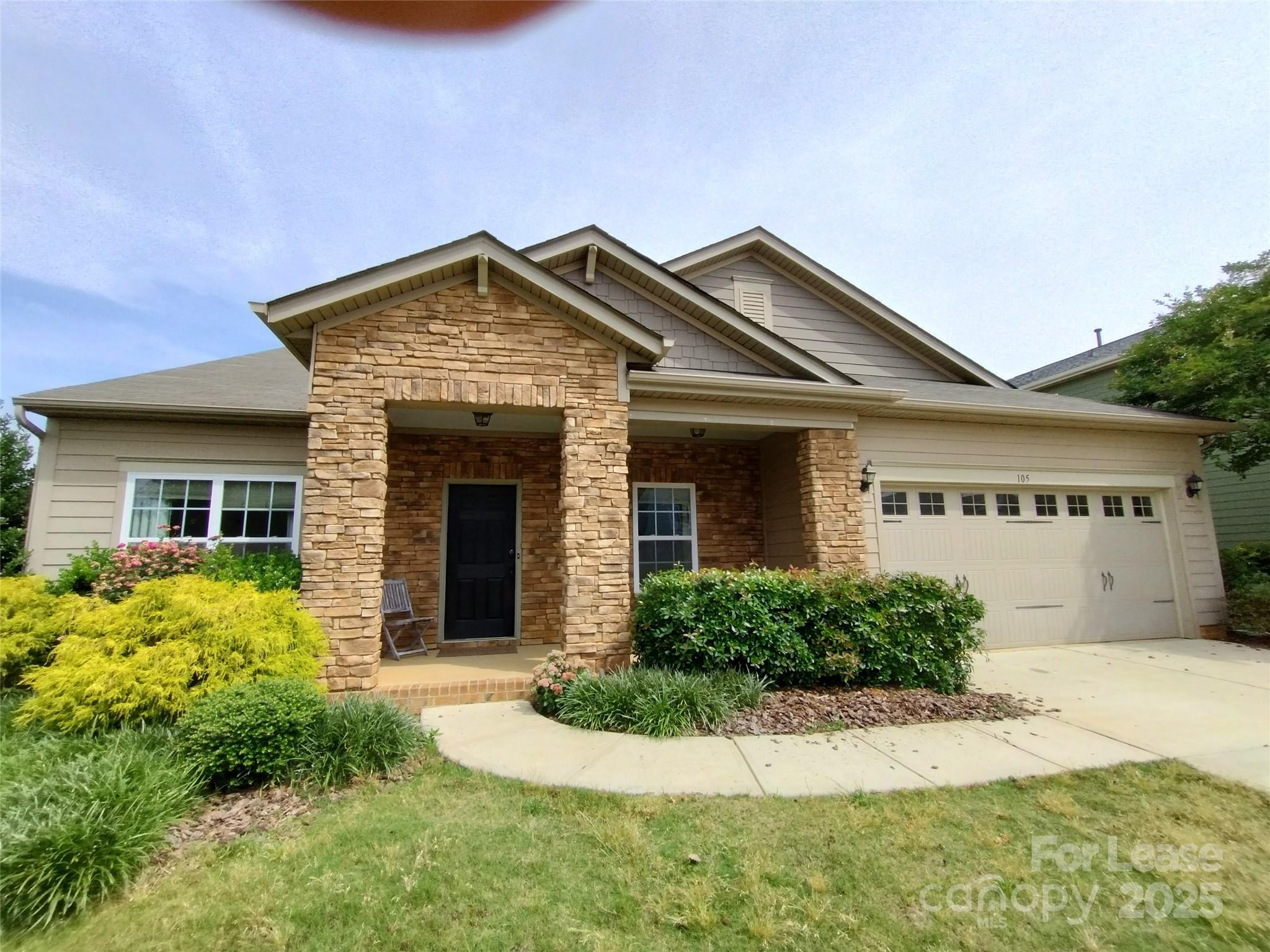 a front view of a house with a garden and plants
