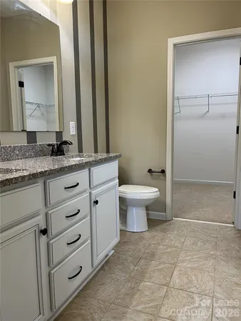 a bathroom with a granite countertop sink a mirror and a shower