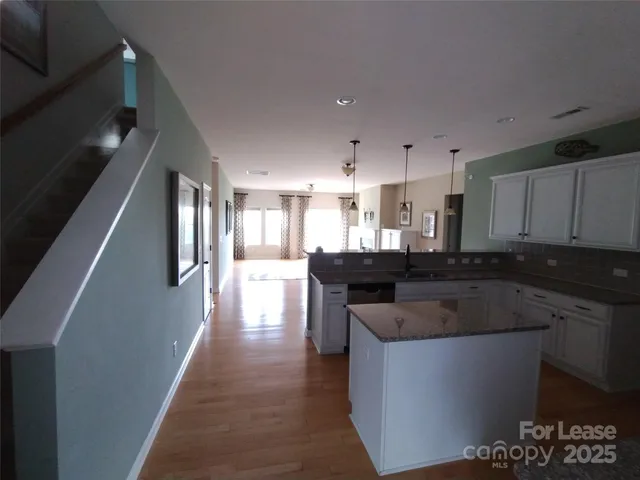 a kitchen with kitchen island stainless steel appliances a sink stove and cabinets