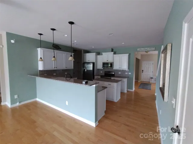 a view of empty room with wooden floor and fireplace
