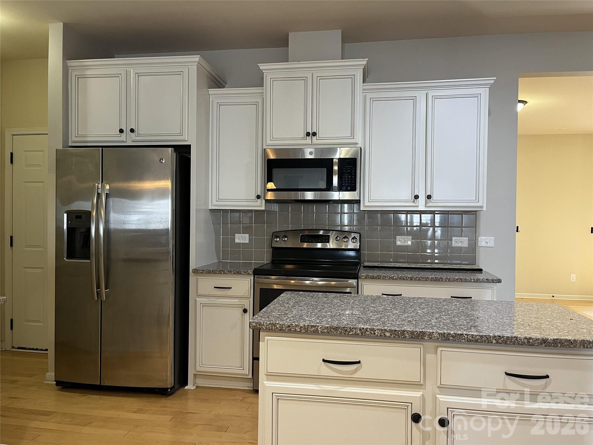 105 East Neel Ranch Road Mooresville, NC 28115 - Photo 5 of 27 a kitchen with granite countertop a refrigerator and a stove