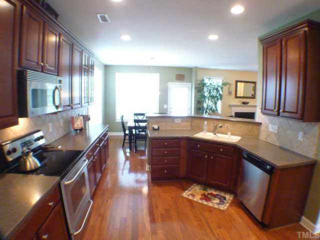 5208 Holly Ridge Farm Road Raleigh, NC 27616 - Photo 4 of 12 a kitchen with stainless steel appliances granite countertop sink stove top oven and cabinets